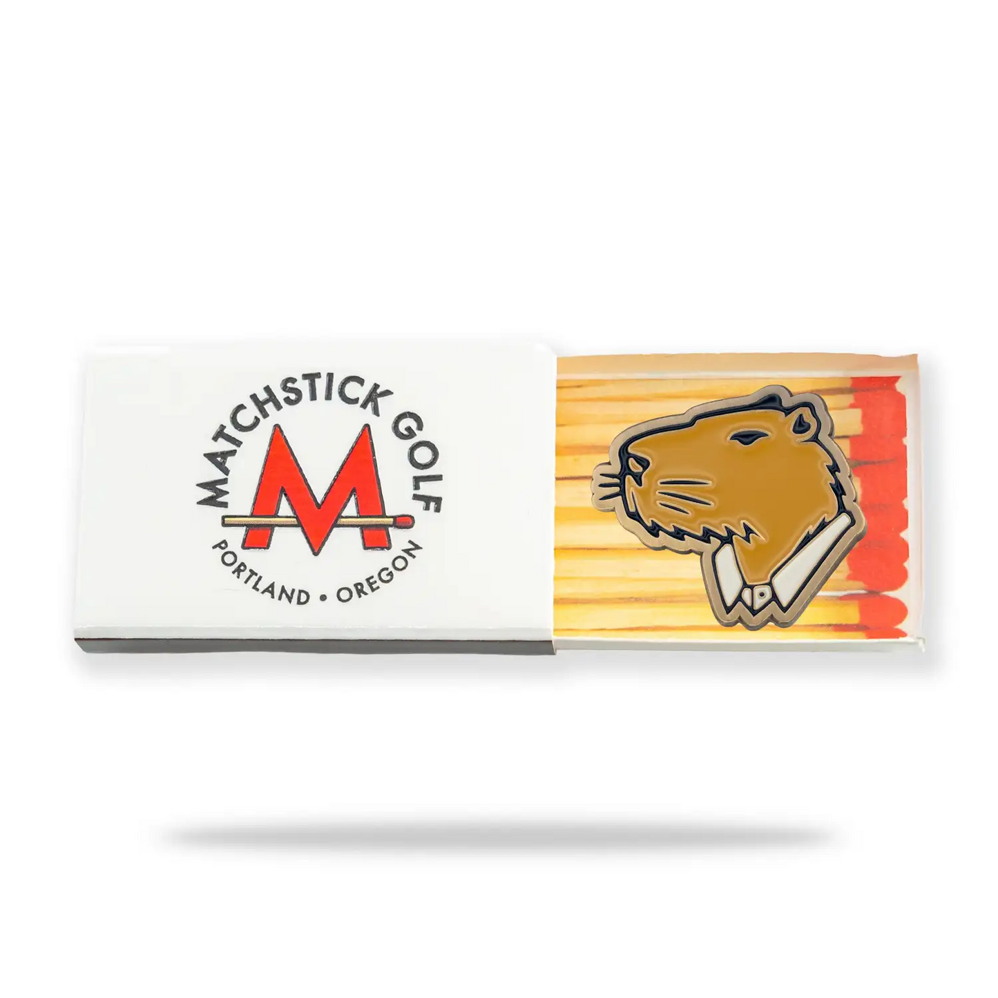 Jolly Golf ball marker placed on top of a matchbox with 'Matchstick Golf' branding on a white background