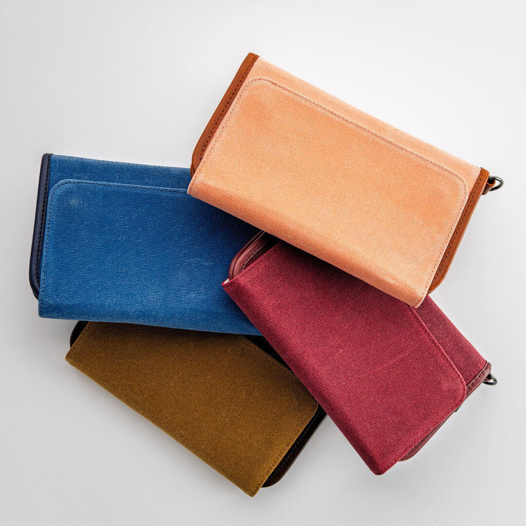 Stack of waxed canvas zippered golf bag organizer pouches by Jolly Golf.