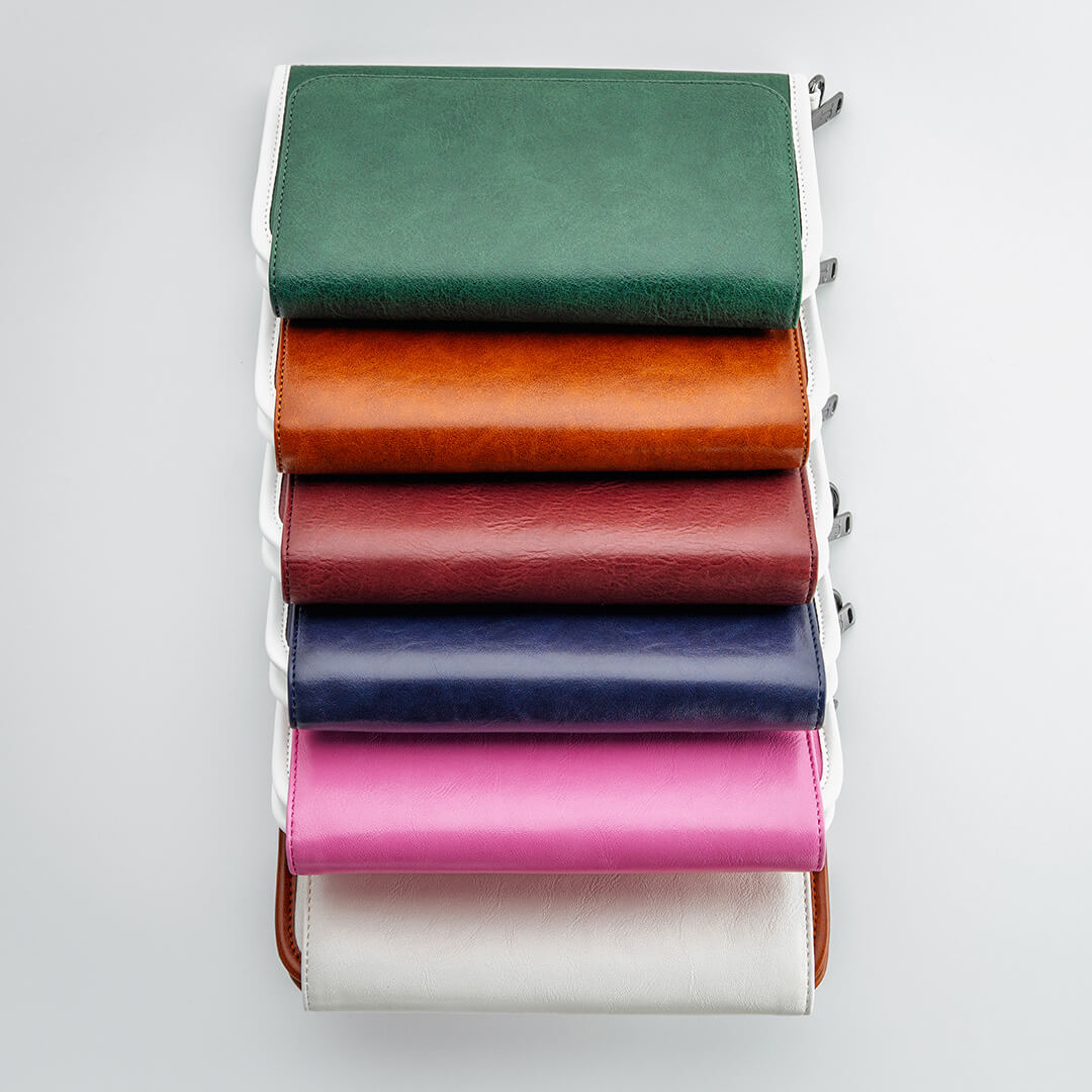 Stack of leather zippered golf bag organizer pouches by Jolly Golf stacked vertically.