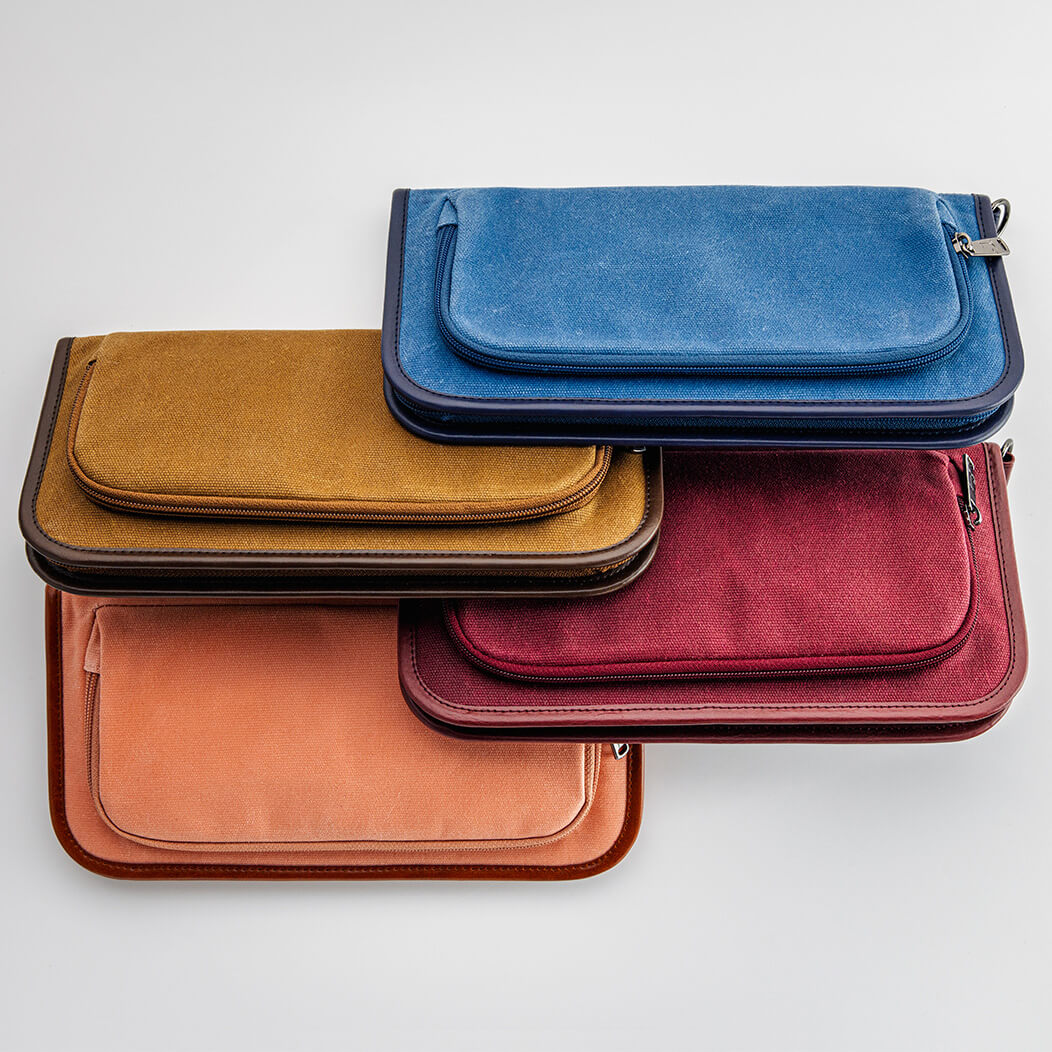 Stack of waxed canvas zippered golf bag organizer pouches by Jolly Golf.