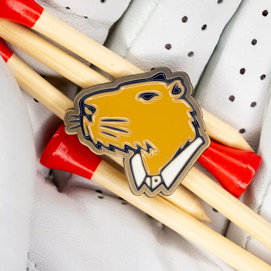 Close up product image of a Jolly golf ball marker placed on top of golf tees for size reference.