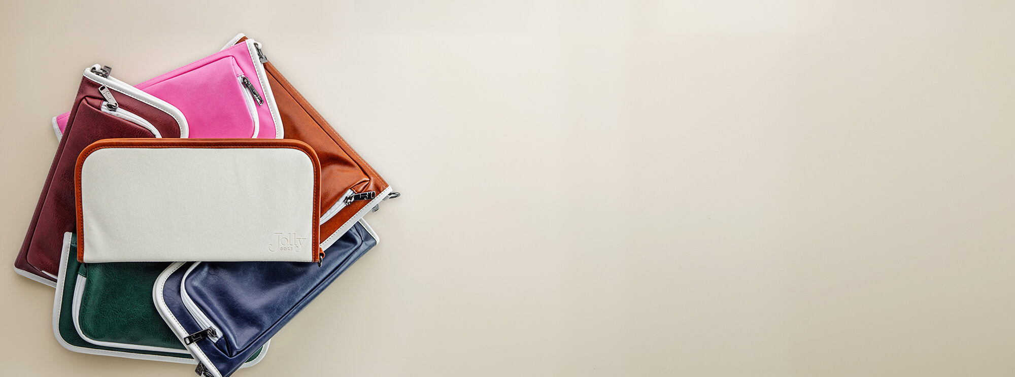 Stack of vegan leather golf bag organizer pouches on a beige background