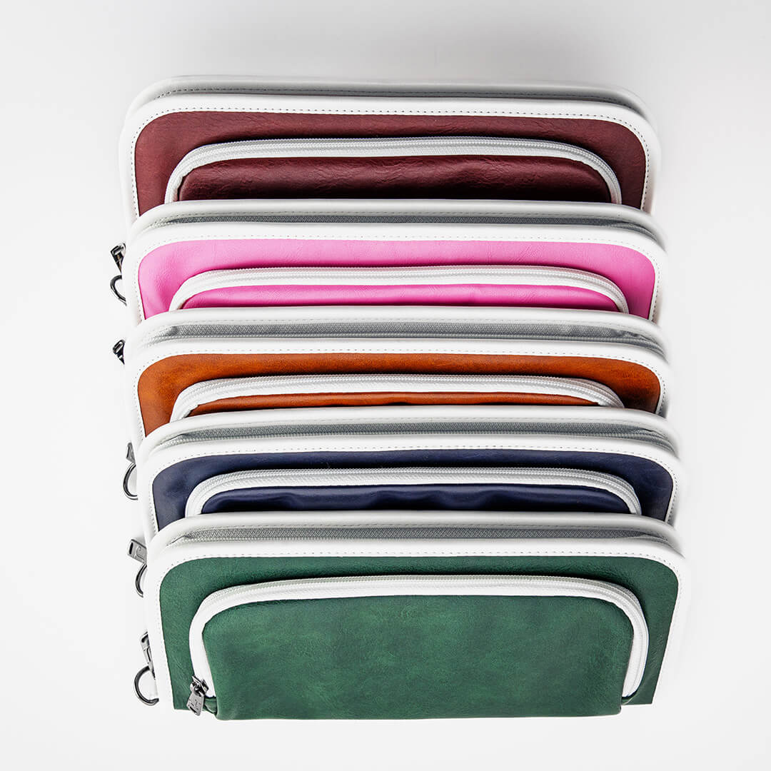 Stack of leather zippered golf bag organizer pouches by Jolly Golf.