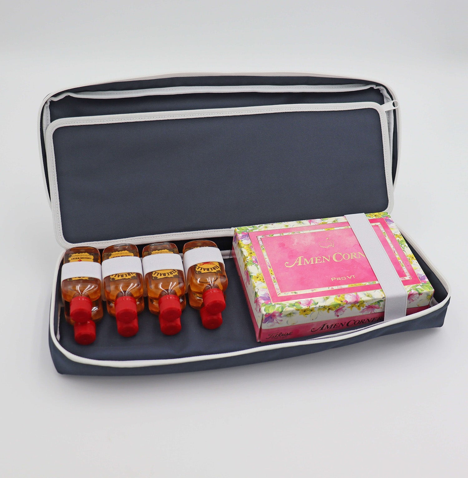 Navy Merrymaker golf organizer shown open with cinnamon whiskey nips and limited edition Masters tournament golf balls inside