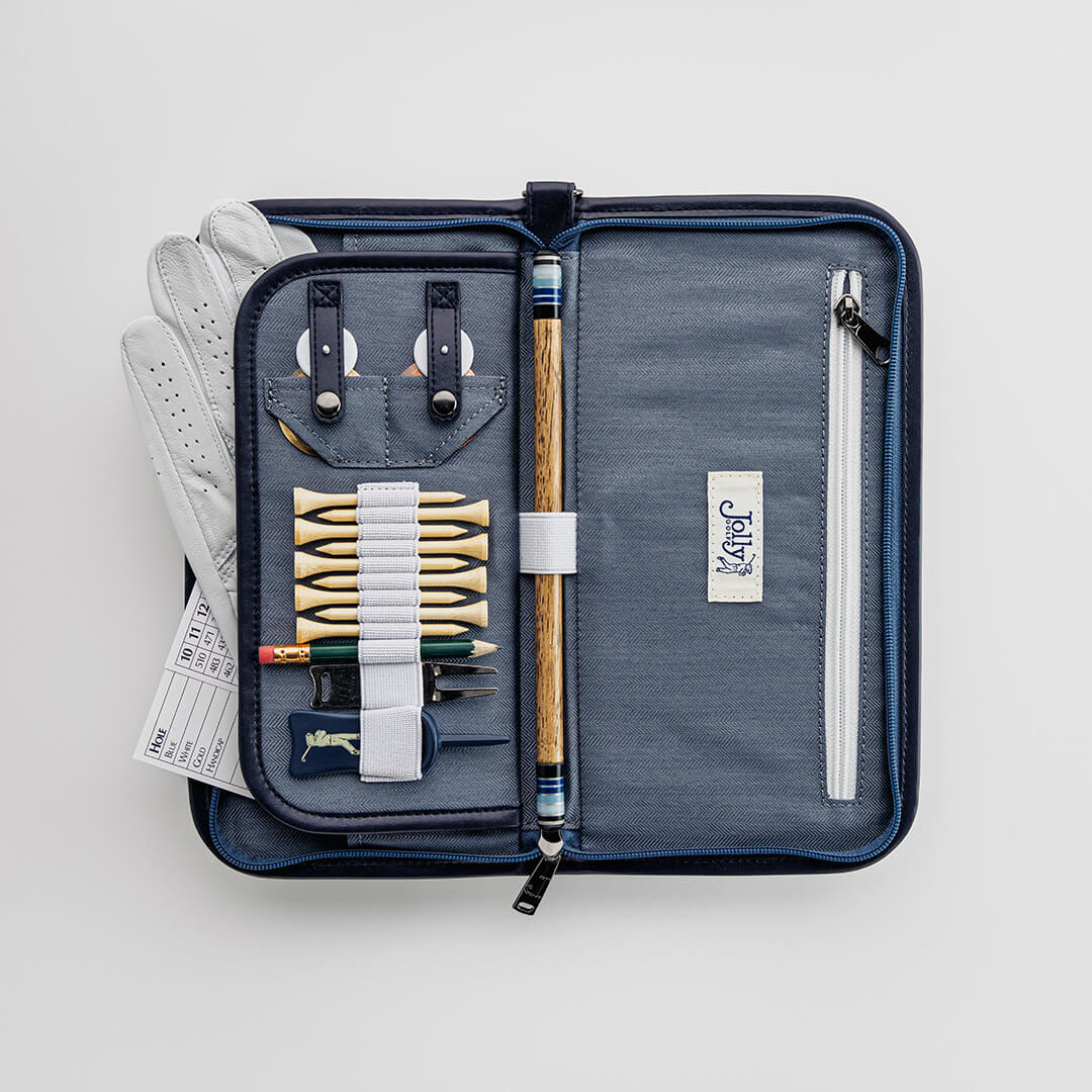 Golf organizer case by Jolly Golf with golf accessories including tees, glove, scorecard, ball markers, and divot tool.